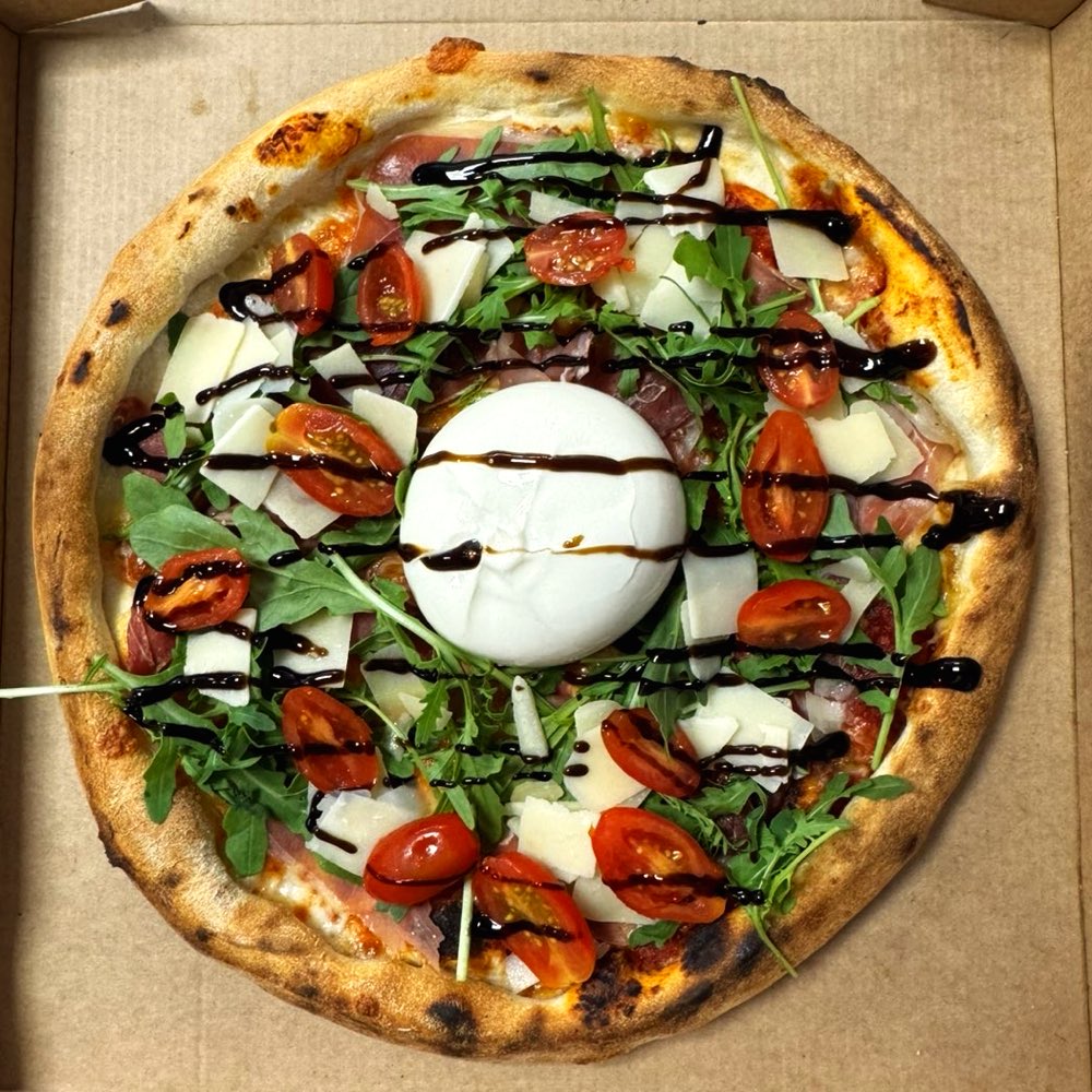 Pizza Burrata de la Pizzeria Gusto : burrata entière, roquette, tomates cerises et crème balsamique